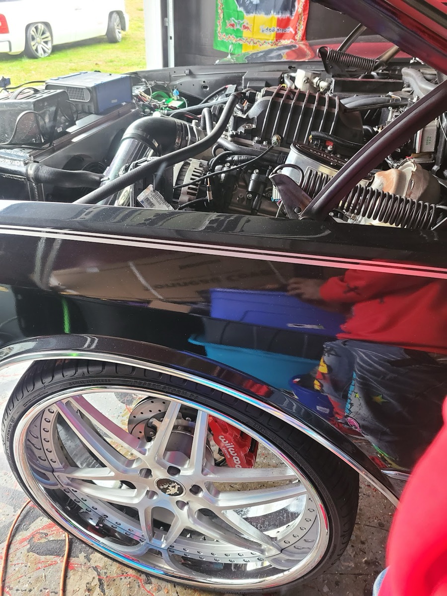 Big custom wheel and red performance brake caliper on a build at L&W Tire